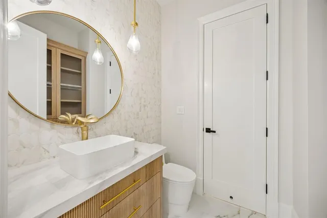 a bathroom with a sink a toilet and a mirror