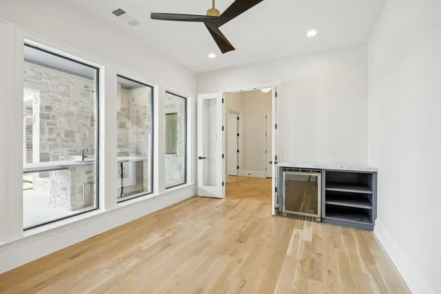 a view of an empty room with a window and wooden floor
