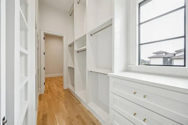 a view of a hallway with wooden floor and closet