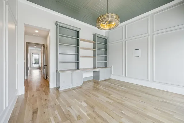 a view of empty room with wooden floor and window