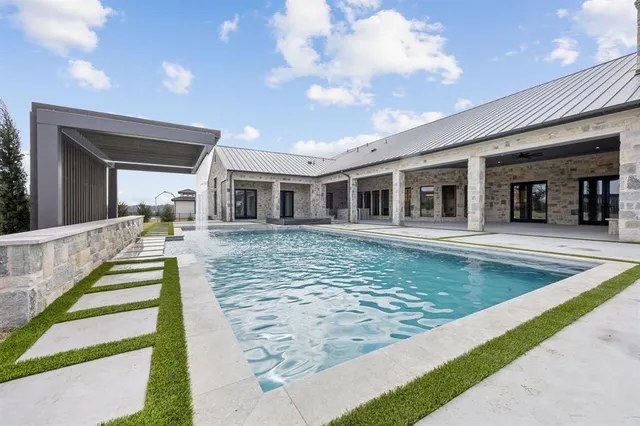 a view of a house with swimming pool and sitting area