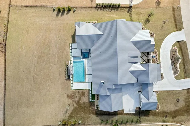 an aerial view of a house with outdoor space and a lake view