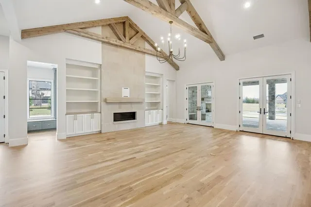 a view of an empty room with a fireplace and a window