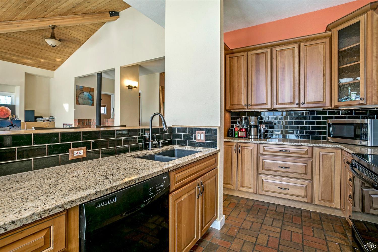 2613 Bear Trap Road Avon, CO 81620 - Photo 7 of 25 a kitchen with granite countertop a sink a stove and cabinets