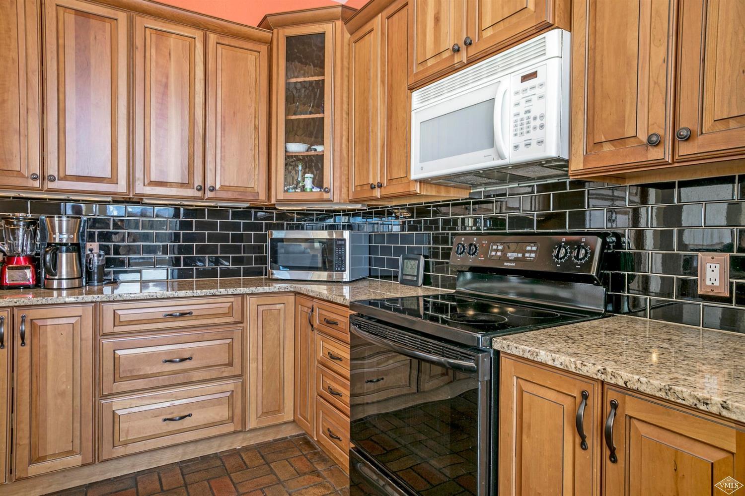 2613 Bear Trap Road Avon, CO 81620 - Photo 8 of 25 a kitchen with stainless steel appliances granite countertop a stove and a microwave