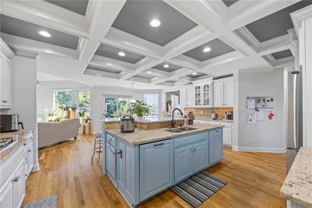 a kitchen with granite countertop a sink stainless steel appliances and cabinets