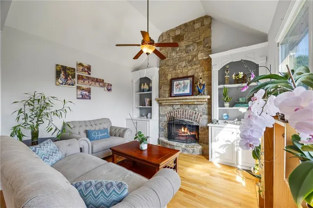 a living room with furniture a fireplace and a floor to ceiling window