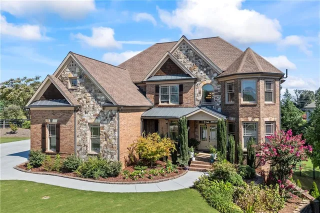 a front view of a house with yard and parking