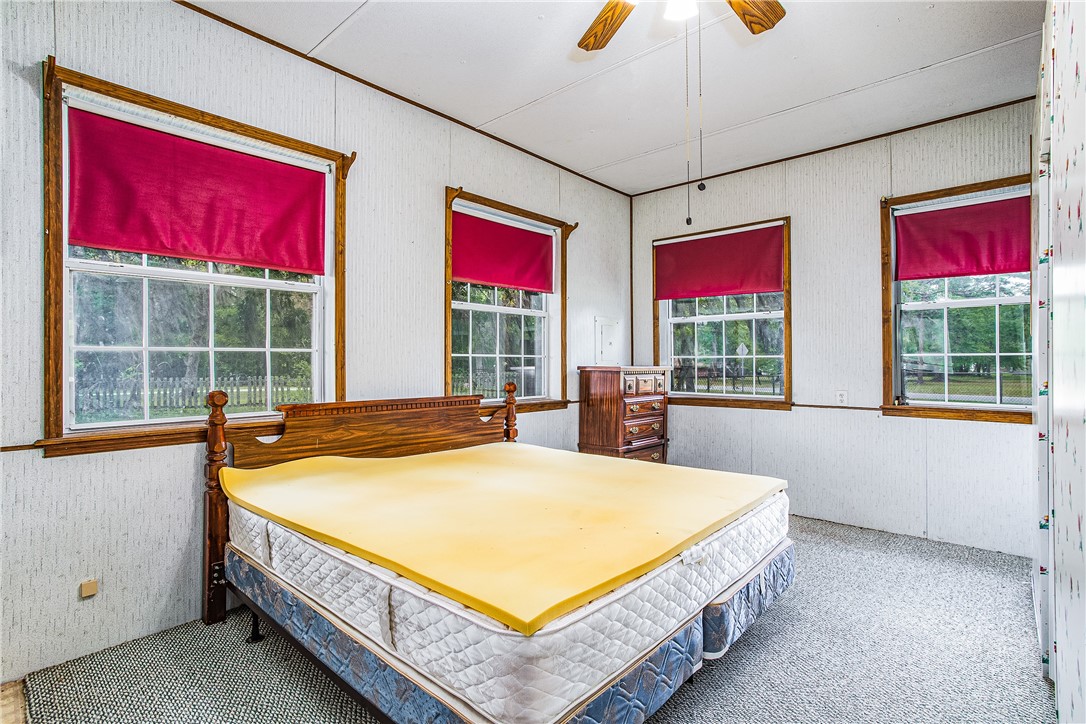 35157 Goodbread Road Callahan, FL 32011 - Photo 26 of 34 a spacious bedroom with a large bed and a chandelier