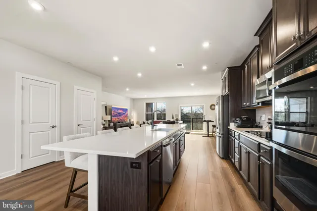 a large kitchen with lots of counter space a sink appliances and dining table