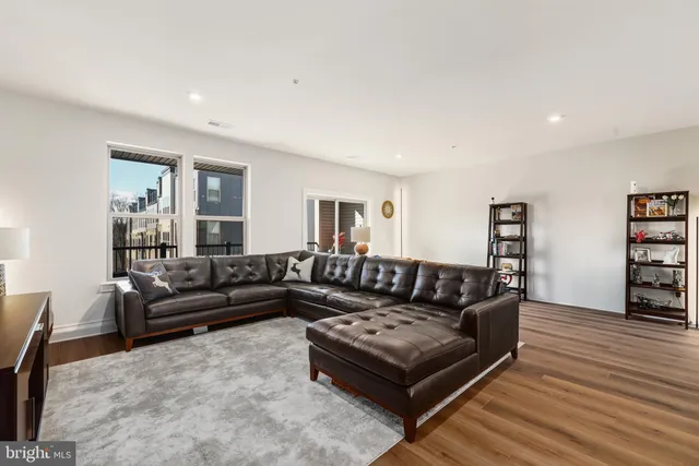 a living room with furniture a flat screen tv and wooden floor