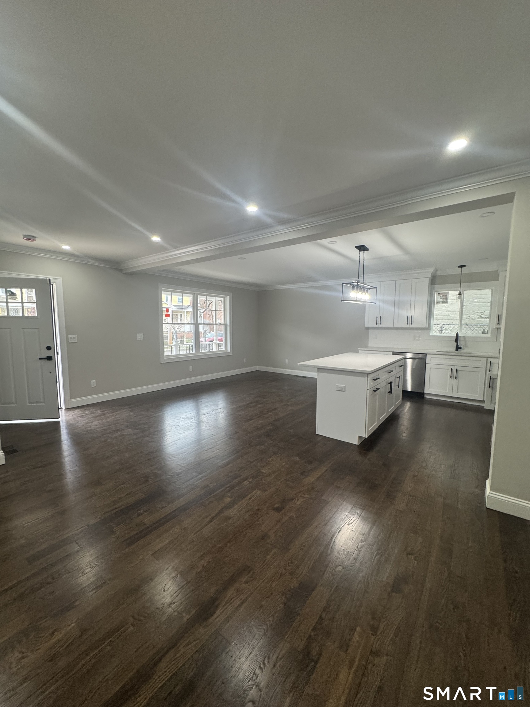 279 Harriet Street Bridgeport, CT 06608 - Photo 5 of 9 an empty room with wooden floor and windows