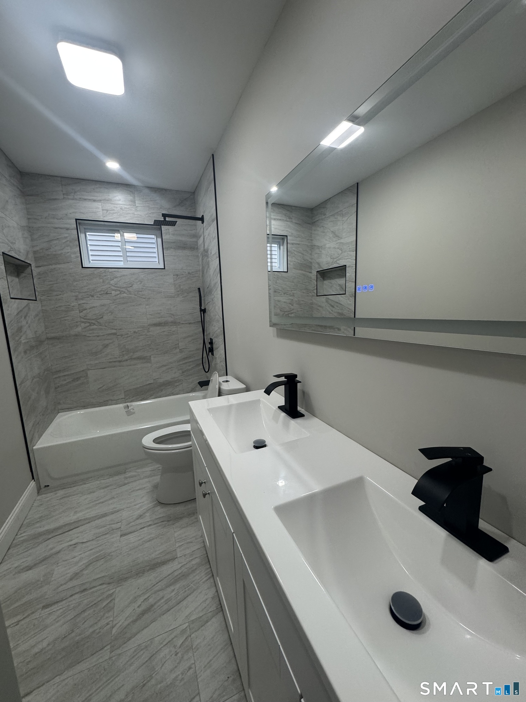 279 Harriet Street Bridgeport, CT 06608 - Photo 6 of 9 a bathroom with a double vanity sink a toilet and a tub