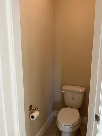 a white toilet sitting next to a shower