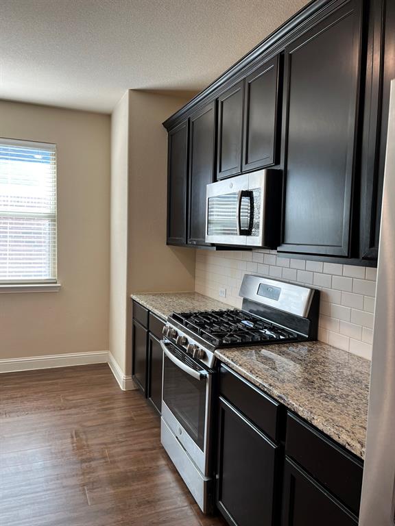 8 Pleasant Valley Sanger, TX 76266 - Photo 5 of 26 a kitchen with stainless steel appliances granite countertop a stove a sink and a microwave
