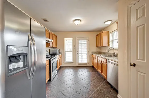 a large kitchen with a large counter top stainless steel appliances and cabinets