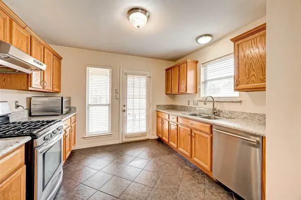 a kitchen with stainless steel appliances granite countertop a stove a sink and a refrigerator