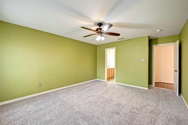an empty room with a ceiling fan and a window