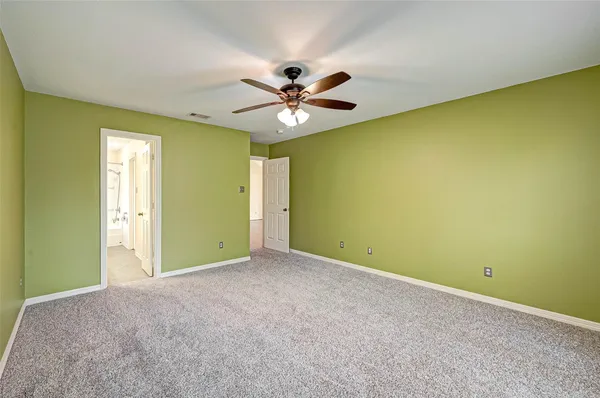 an empty room with a ceiling fan and a window