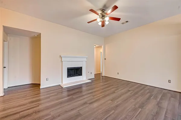 an empty room with wooden floor and a fireplace