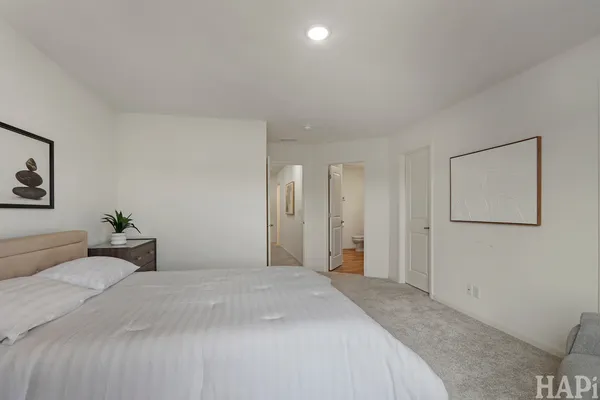 a bedroom with a large bed and painting on the wall