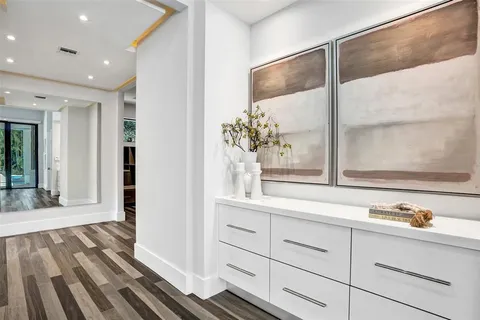 a utility room with cabinets and wooden floor