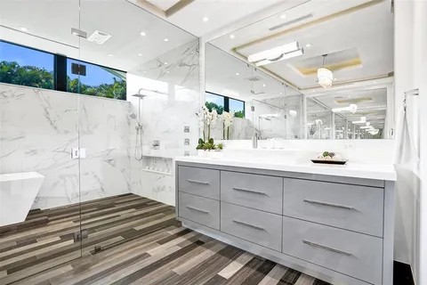 a bathroom with a sink a mirror and a shower