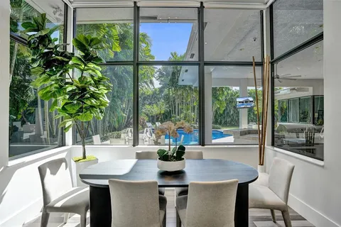 a view of a patio with table and chairs potted plants and palm trees