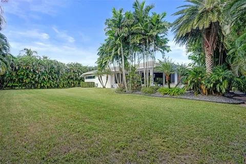 an aerial view of residential houses with outdoor space and trees