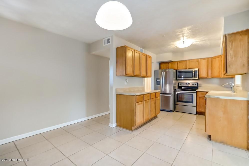 4427 Barnes Road South Jacksonville, FL 32207 - Photo 13 of 39 a kitchen with granite countertop a stove top oven and cabinets