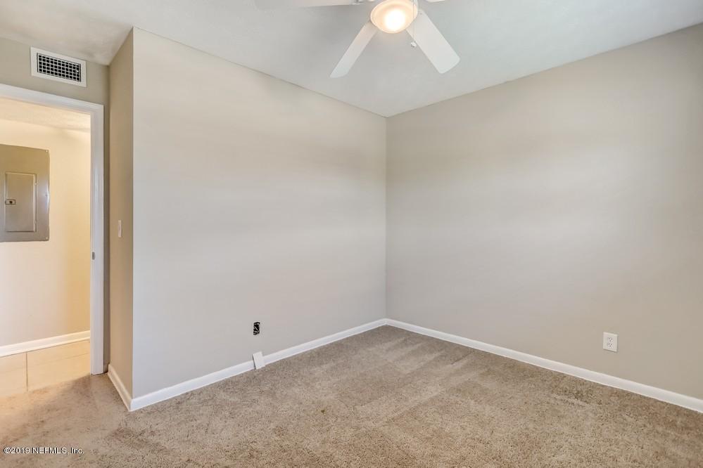 4427 Barnes Road South Jacksonville, FL 32207 - Photo 30 of 39 an empty room with a chandelier fan