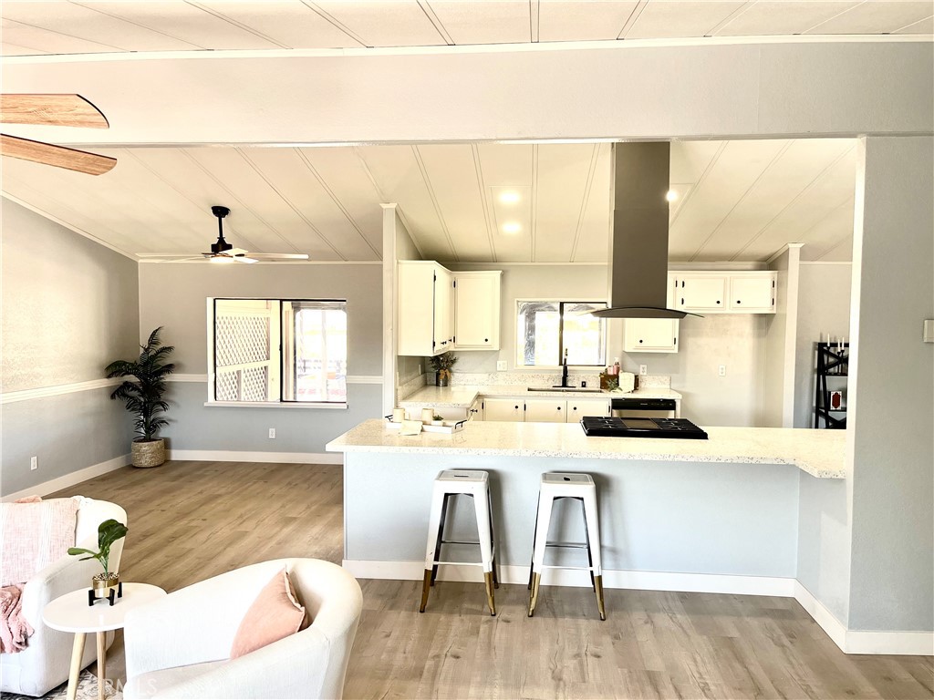 16336 Yuma Road Apple Valley, CA 92307 - Photo 2 of 18 a living room with stainless steel appliances kitchen island granite countertop a sink a stove and white cabinets with wooden floor