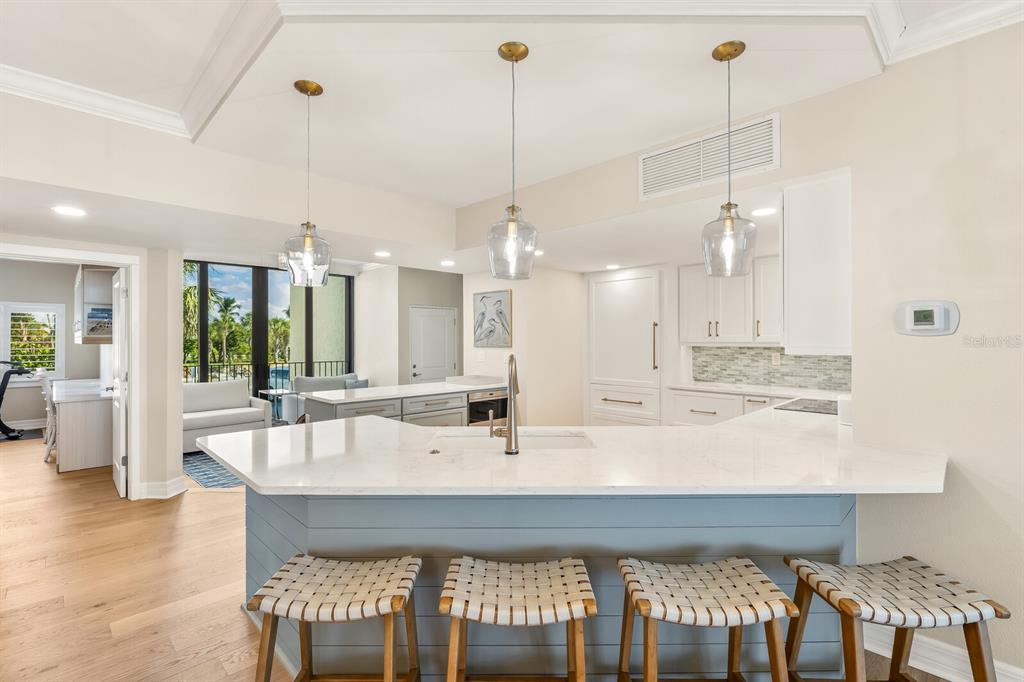 5000 Gasparilla Road, Unit 29A Boca Grande, FL 33921 - Photo 10 of 40 a large white kitchen with a large island oven a sink dishwasher white cabinets and couches