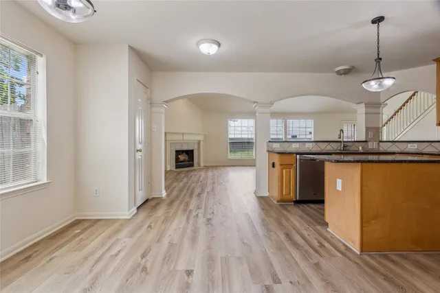 a view of a kitchen center island wooden floor and stainless steel appliances