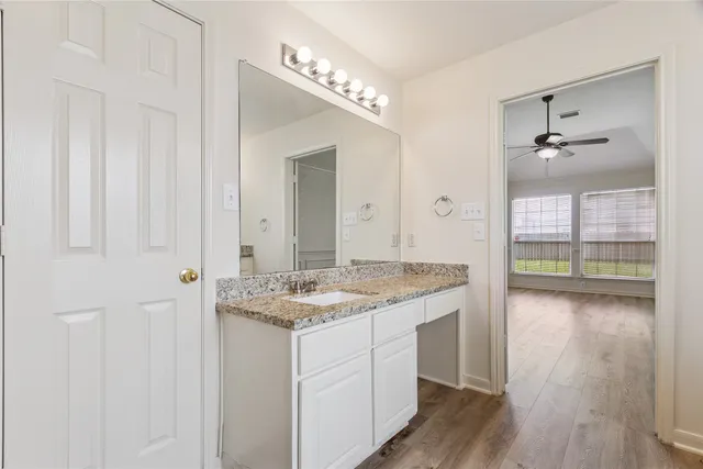 a bathroom with a granite countertop sink and a mirror
