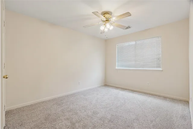 an empty room with a chandelier fan