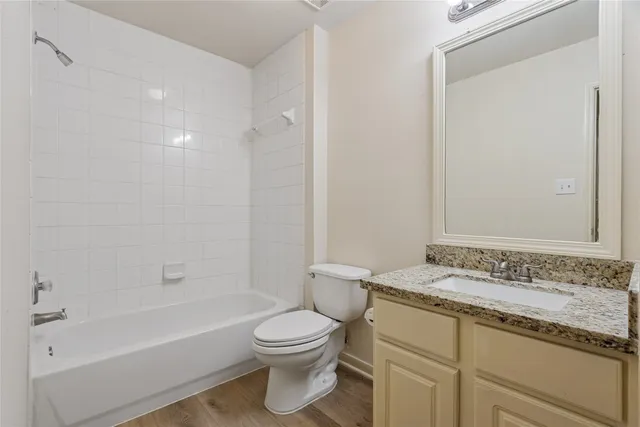 a bathroom with a granite countertop sink a toilet and shower