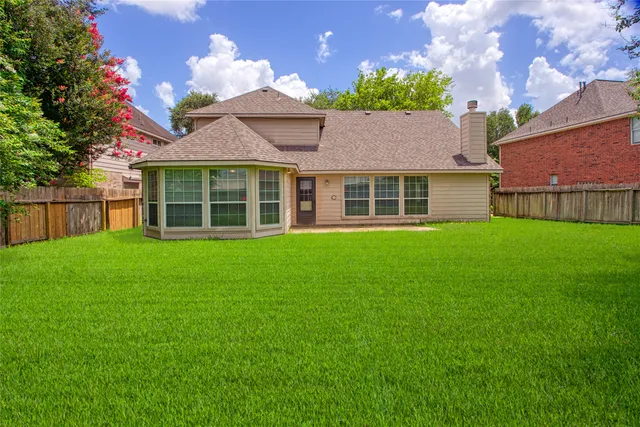 a front view of a house with a yard and potted plants