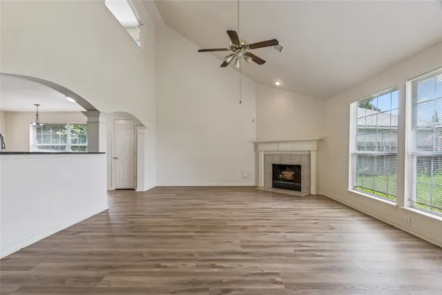 a view of a livingroom with a fireplace window and wooden floor