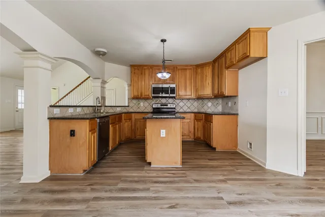 a kitchen with stainless steel appliances granite countertop a stove a sink dishwasher and a refrigerator