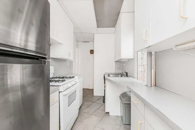 a kitchen with white cabinets and white appliances