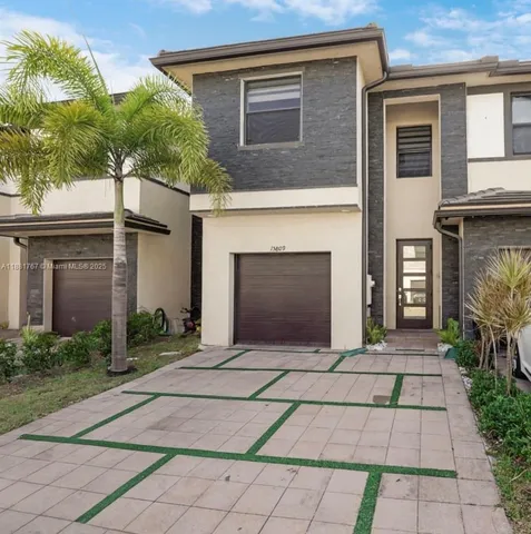 a front view of house with yard and trees around