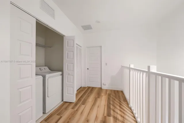 a view of a hallway with wooden floor and staircase