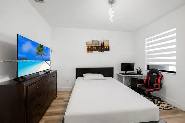 a bedroom with a bed and a flat screen tv