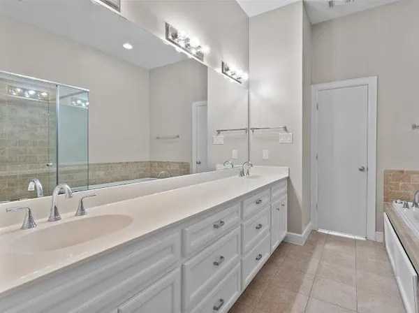 a bathroom with double vanity sink and a mirror
