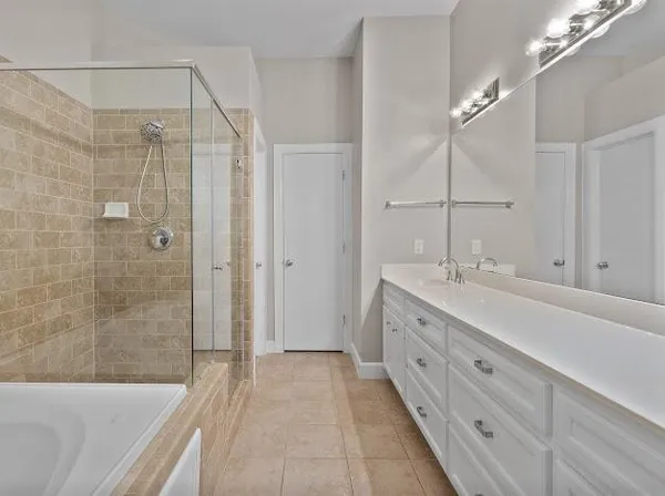 a spacious bathroom with a double vanity sink toilet mirror and bathtub