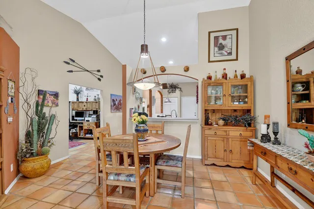 a kitchen with stainless steel appliances kitchen island granite countertop a table and chairs in it