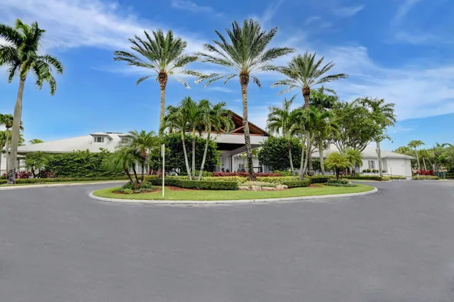 a view of a house with a yard and palm trees
