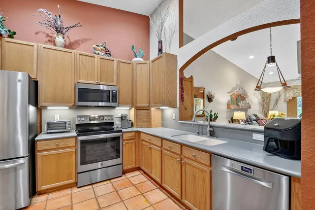 a kitchen with stainless steel appliances a stove refrigerator sink and microwave