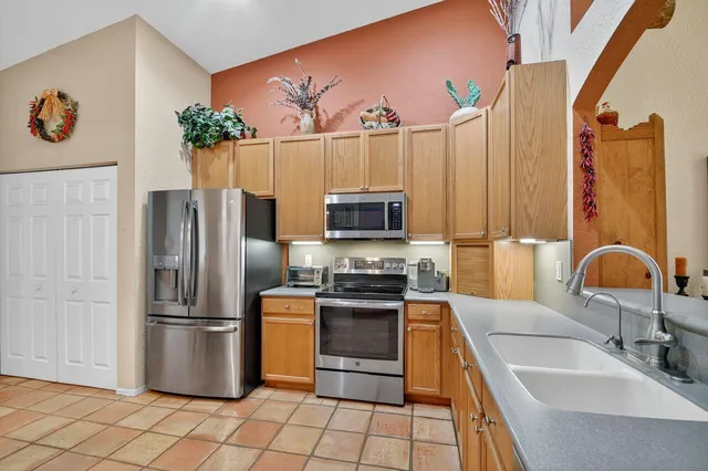 a kitchen with stainless steel appliances granite countertop a refrigerator and a sink
